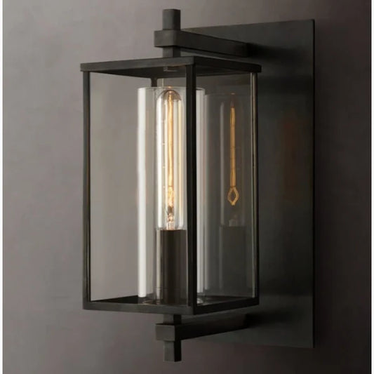 Front view of Ariel brass glass wall sconce mounted on a neutral studio wall