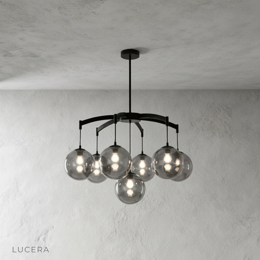 Studio view of copper chandelier with clear ribbed glass lampshades hanging centered against neutral backdrop