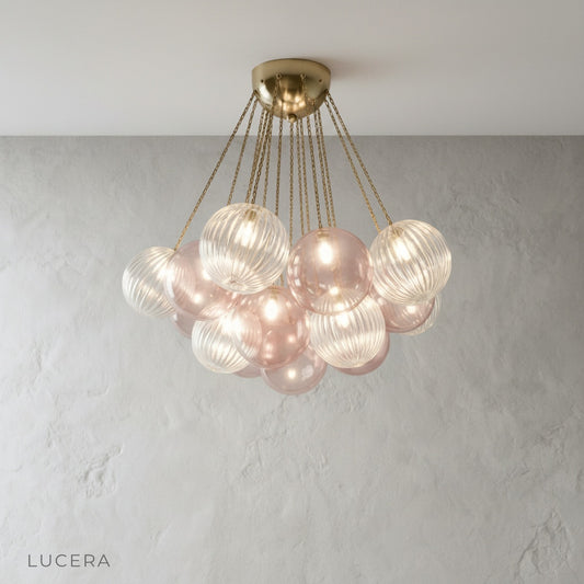 Studio shot of Brezza chandelier with clear glass globes on brushed metal frame