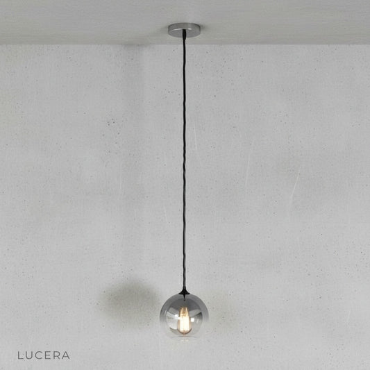Front view of Lucera green gold ombre glass pendant light in minimalist studio setting