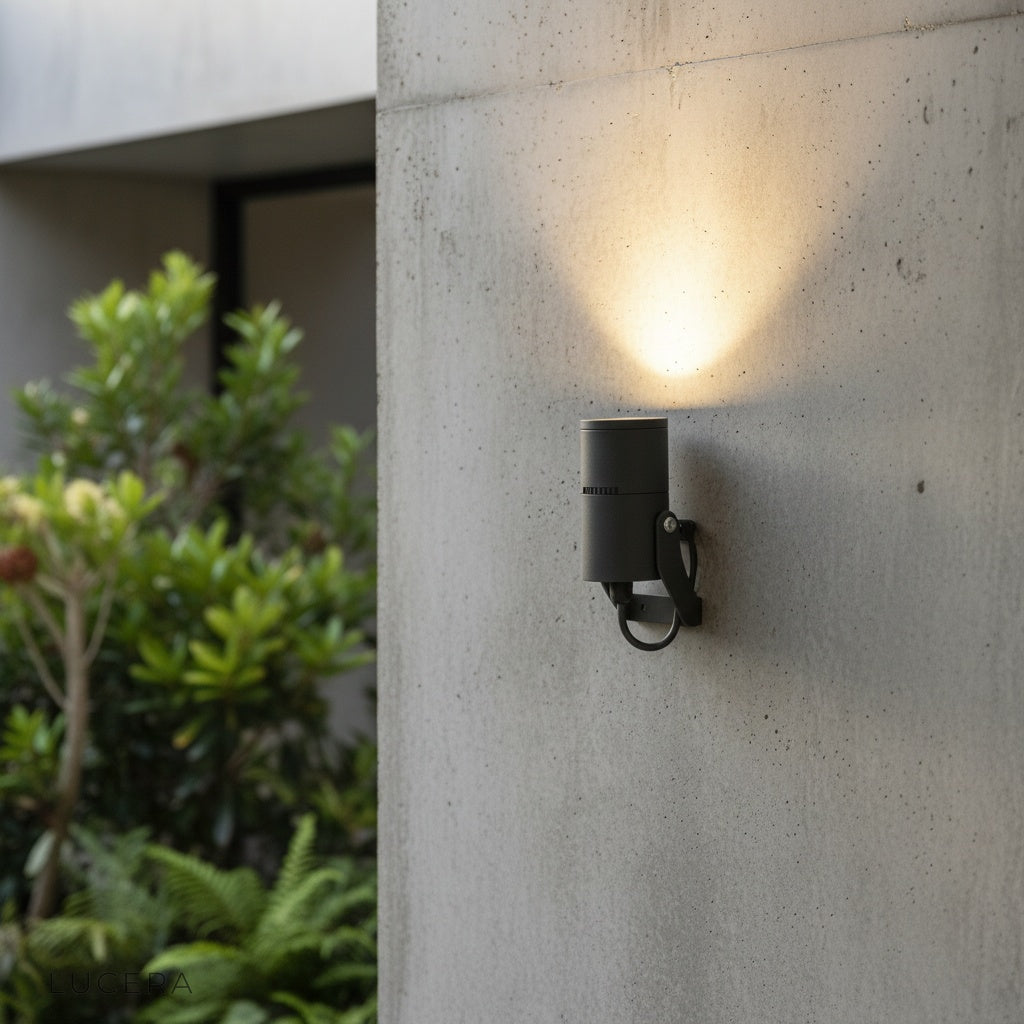 modern black outdoor spotlight illuminating a contemporary patio wall at dusk