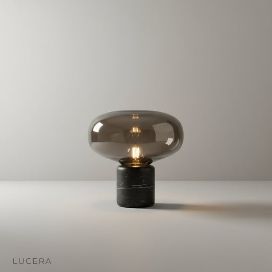 Studio shot of Elegance Table Lamp front view, tinted glass dome over white marble cylinder base on neutral background