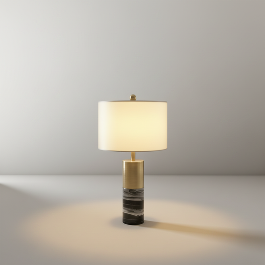 Studio shot of Essere Table Lamp with cylindrical marble base and metal accent on clean white background