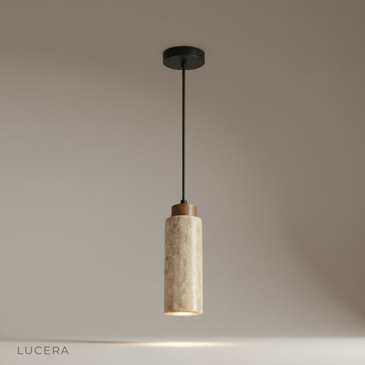 Studio shot of Clandestine pendant light with natural travertine dome shade on sleek black cable against white background