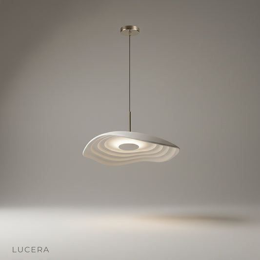 studio shot of wavy rippling brass pendant light on white background