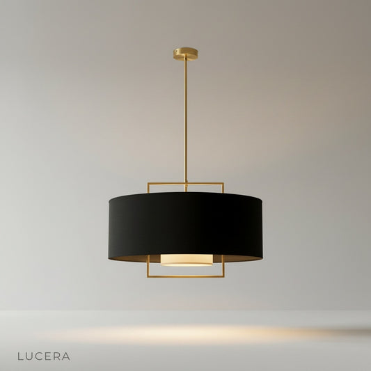 Studio shot of Permanent Green pendant light with black fabric shade and brass geometric frame on clean white background