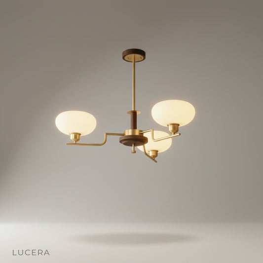 studio shot of Eronix chandelier with three globe glass shades and curved brass arms on white background