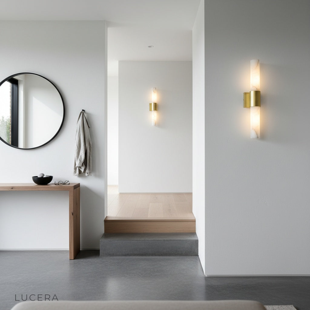Umbra Alabaster wall sconce casting warm glow in an elegant entryway at night