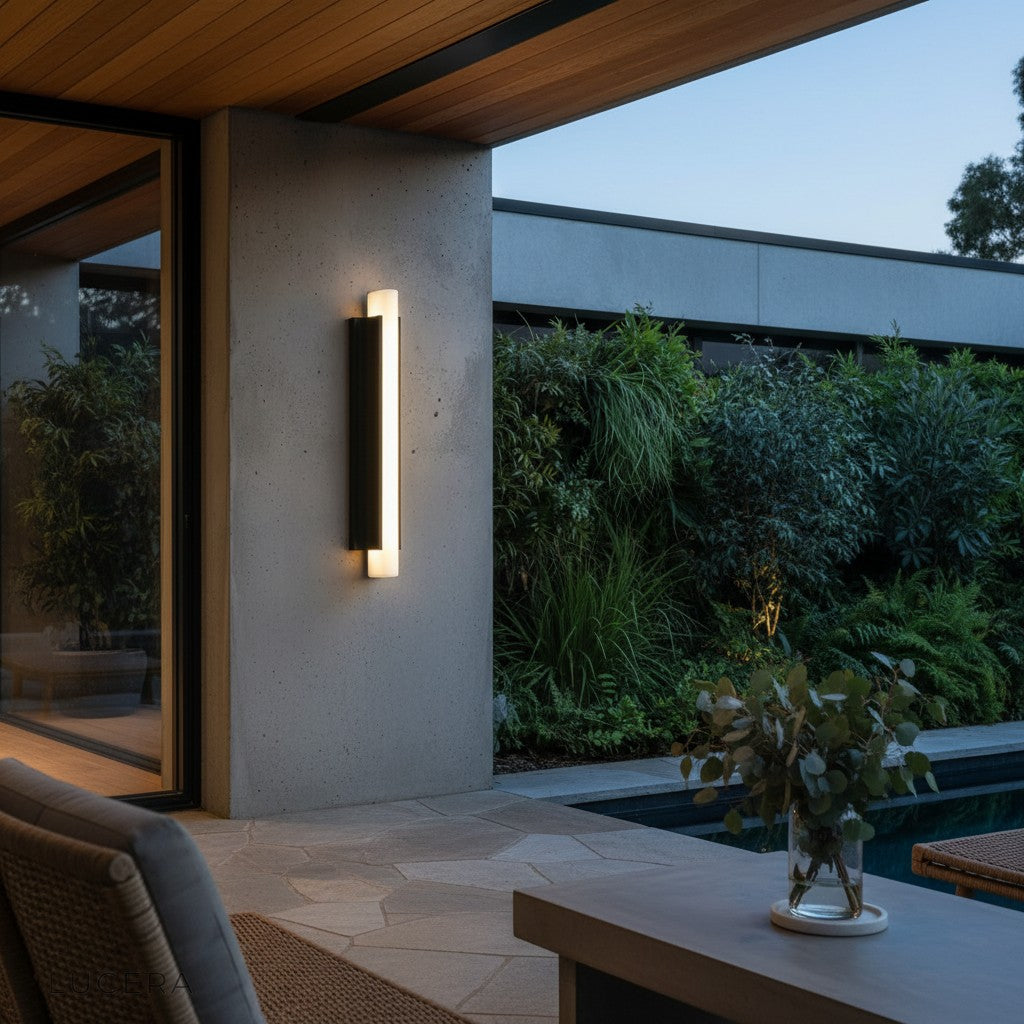 Corvus outdoor wall light glowing warm white on a contemporary stucco wall