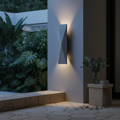 Outdoor travertine sconce illuminating a cozy seating area with warm shadows