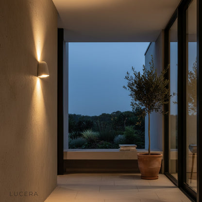 Warm ambient glow from Eos Architectural Microcement Wall Light illuminating a minimalist patio