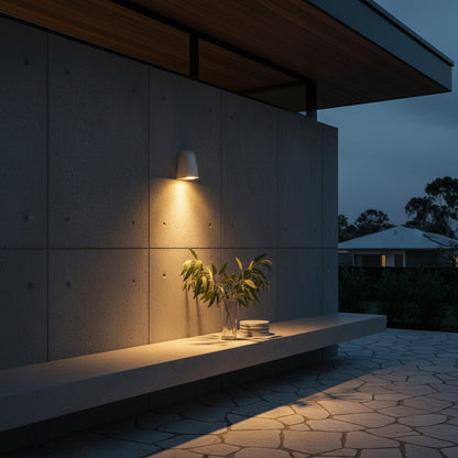 Moody dusk scene with Lucera Eos wall light highlighting a textured plaster outdoor wall
