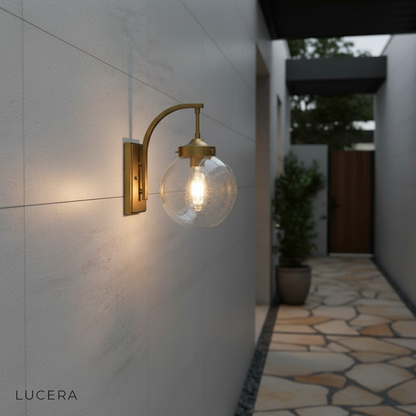 Pair of Nyx wall lights flanking an outdoor seating area in soft evening light