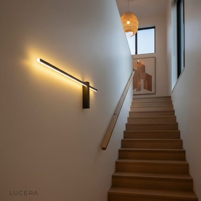 Aether sconce in matte black finish mounted on textured concrete wall