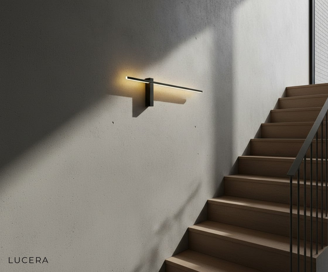 Two Aether sconces flanking a modern entry door with warm evening glow
