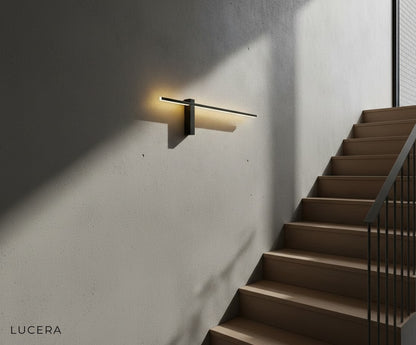 Two Aether sconces flanking a modern entry door with warm evening glow