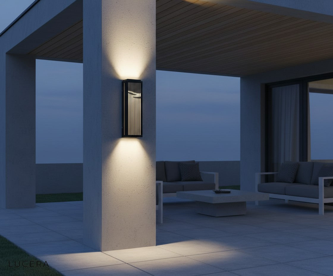 final lifestyle view of Rhea lamp glowing beside an outdoor dining table