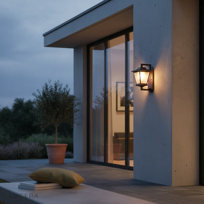 Ophelia Outdoor Sconce casting ambient light over a modern porch with stone texture