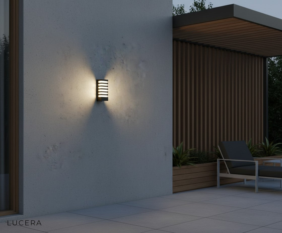 outdoor wall light illuminating a cozy covered porch with seating and plants