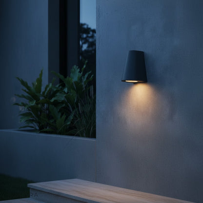 nighttime garden wall lit by Avery LED lamp with plants and pathway in background