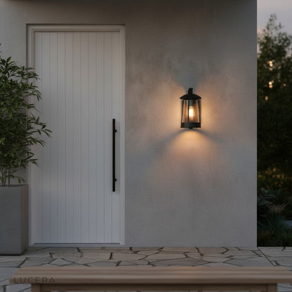 Camille outdoor wall lamp with warm LED light illuminating a brick exterior wall