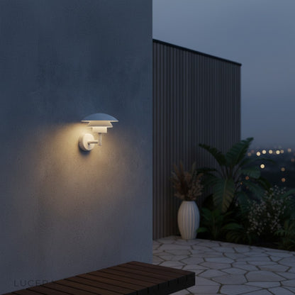 Delphine Outdoor LED Light warm white glow against dark brick wall in backyard