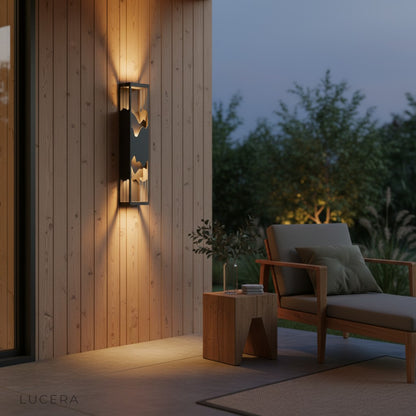 Renee wall light casting warm light on stone pathway at night