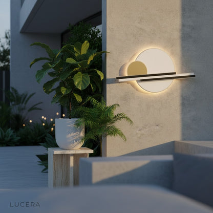 Zola black and gold wall sconce on wooden deck at dusk with soft lighting