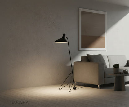 modern tripod floor lamp beside armchair in warm neutral lounge