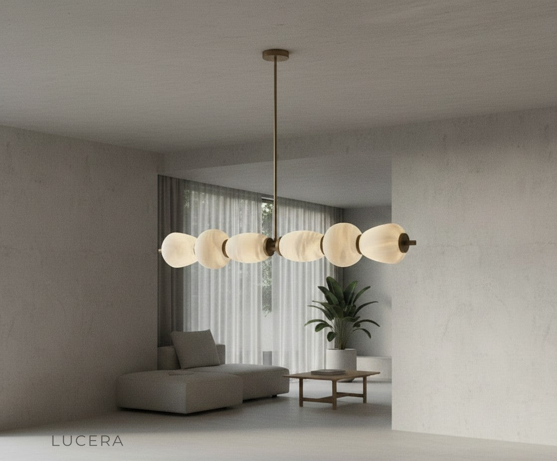 ochre marble chandelier glowing softly in cozy reading nook with linen armchair and plants