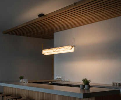 Nighttime lifestyle shot of the Viridian pendant light casting layered shadows on a brick wall