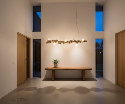 aesthetic moody shot of bubble glass chandelier reflecting in mirror above dark console table