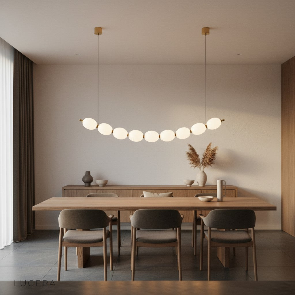 Chrome string of pearls pendant chandelier hanging above bedside table in cozy bedroom with soft lighting