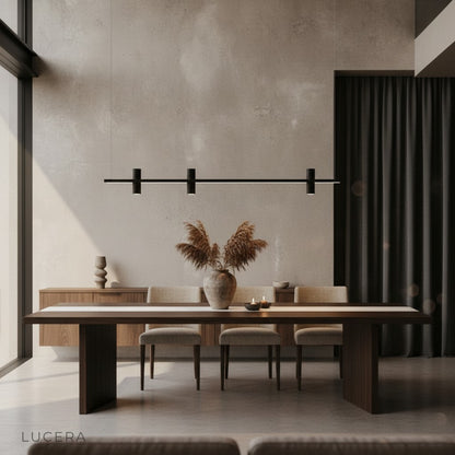 Feldgrau linear chandelier casting ambient light in cozy evening living room setting