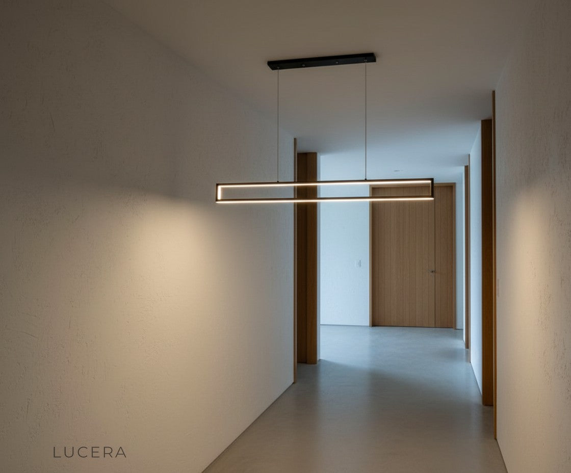 Ingrid chandelier in a high-ceiling open-plan space at night, emphasizing its sleek linear silhouette