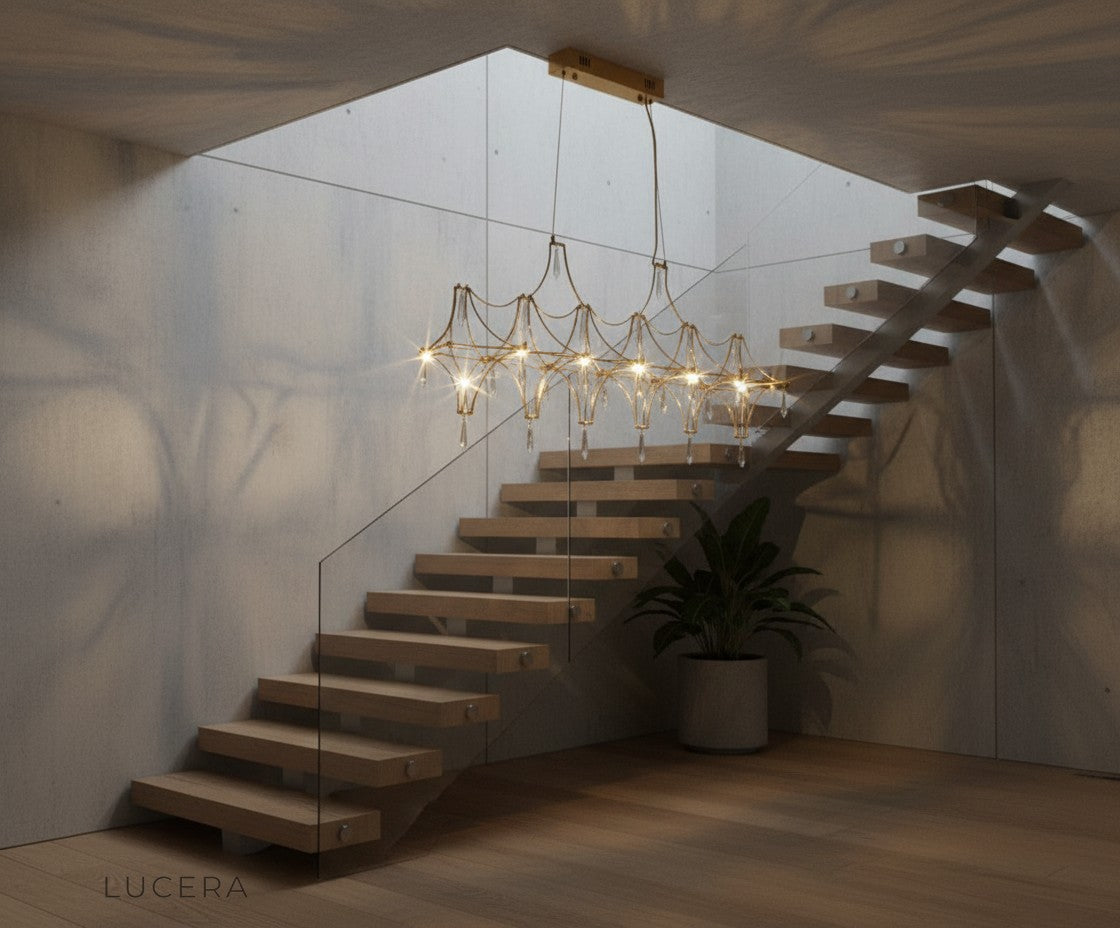 nighttime lifestyle shot of Leif chandelier glowing in high-ceiling living room