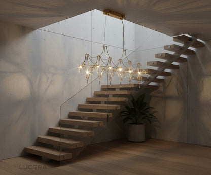 nighttime lifestyle shot of Leif chandelier glowing in high-ceiling living room
