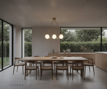 Verdandi copper chandelier with gold glass globes in minimalist interior at dusk