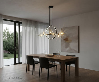 evening shot of Vor glass bubble chandelier illuminating rustic dining room with brick wall