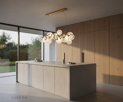 Calmo chandelier in high-ceiling entryway with white panels and soft daylight