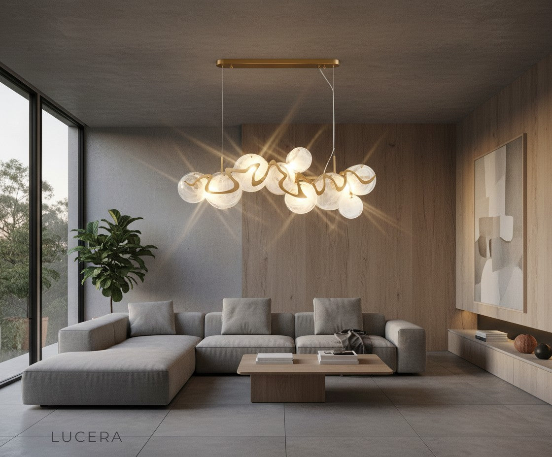 nighttime lifestyle shot of Calmo gold glass chandelier illuminating cozy dining nook