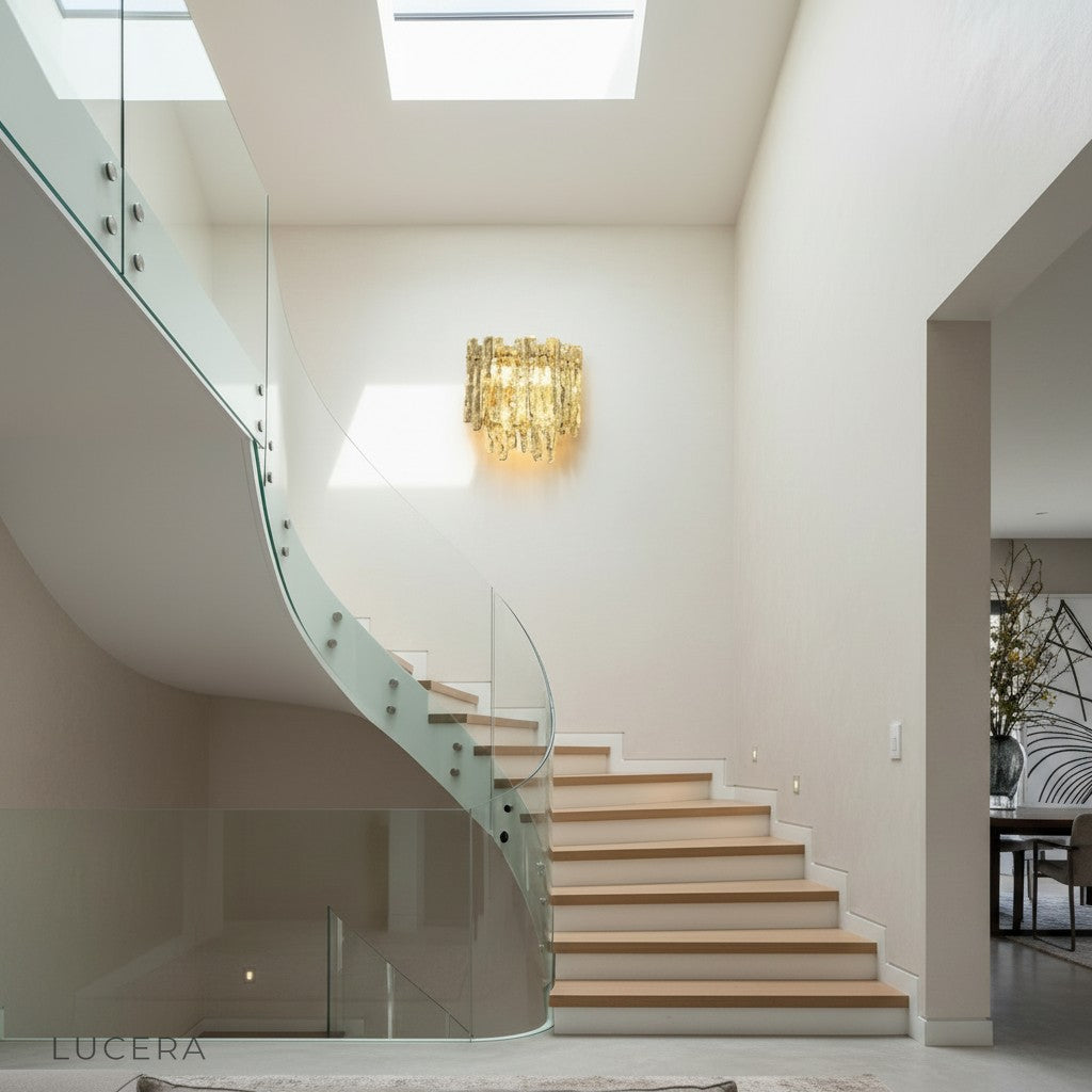 Cielo wall light in brushed brass finish with amber glass shade in minimalist hallway