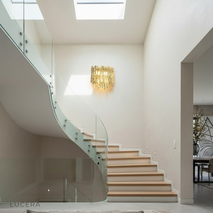 Cielo wall light in brushed brass finish with amber glass shade in minimalist hallway