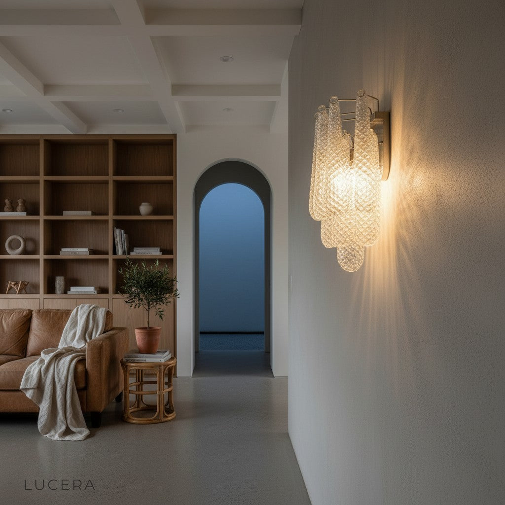 Nighttime ambient shot of glass wall sconce glowing beside a velvet sofa in a stylish lounge setting