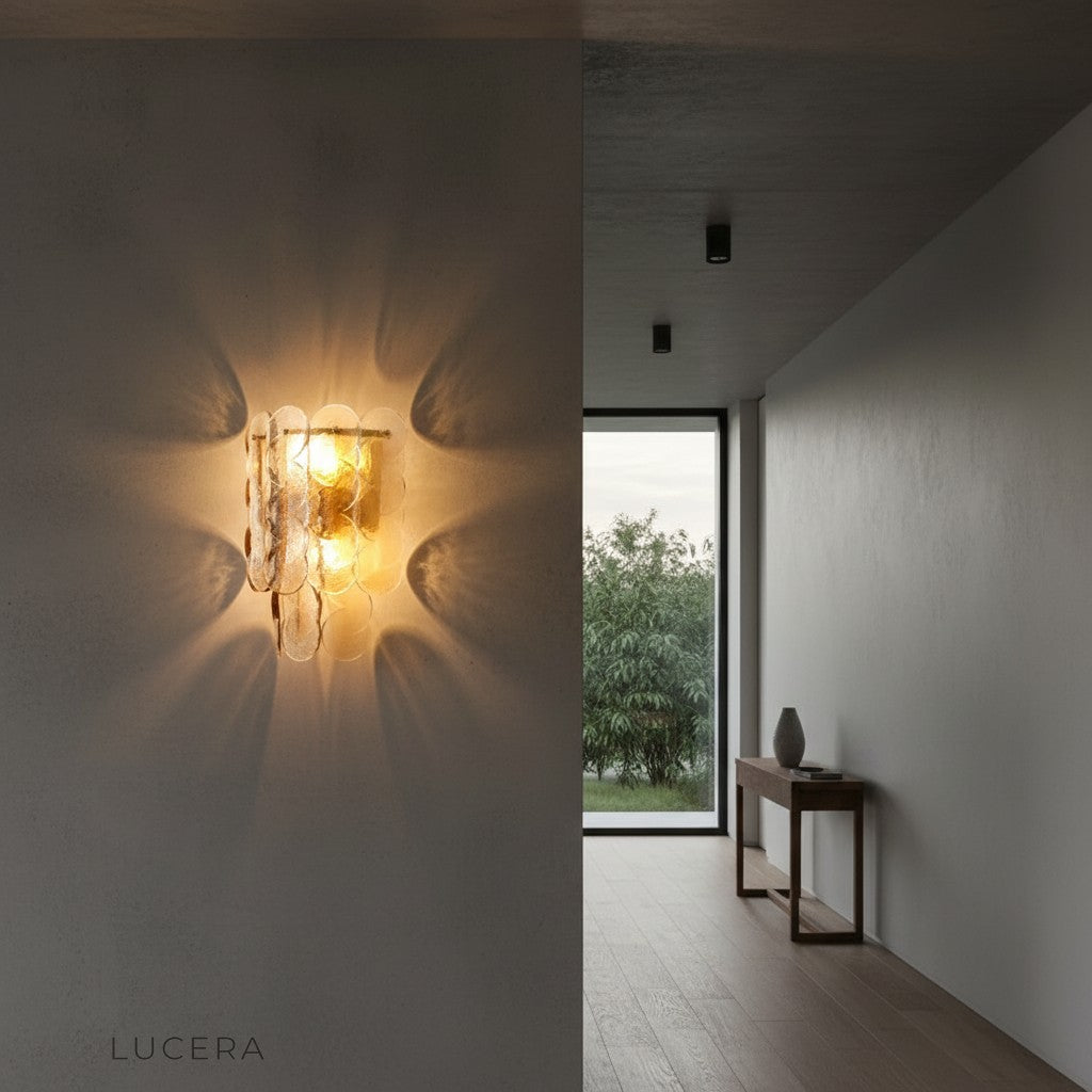 Colmo Caspian textured glass sconce above bed in contemporary bedroom with soft shadows
