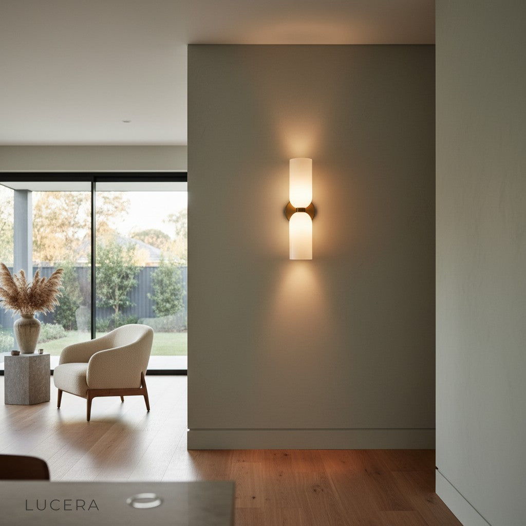 Dolce double sconce with warm ambient light casting soft glow on textured plaster wall