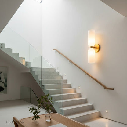 Pair of Dolce white glass wall sconces flanking a modern console table in hallway