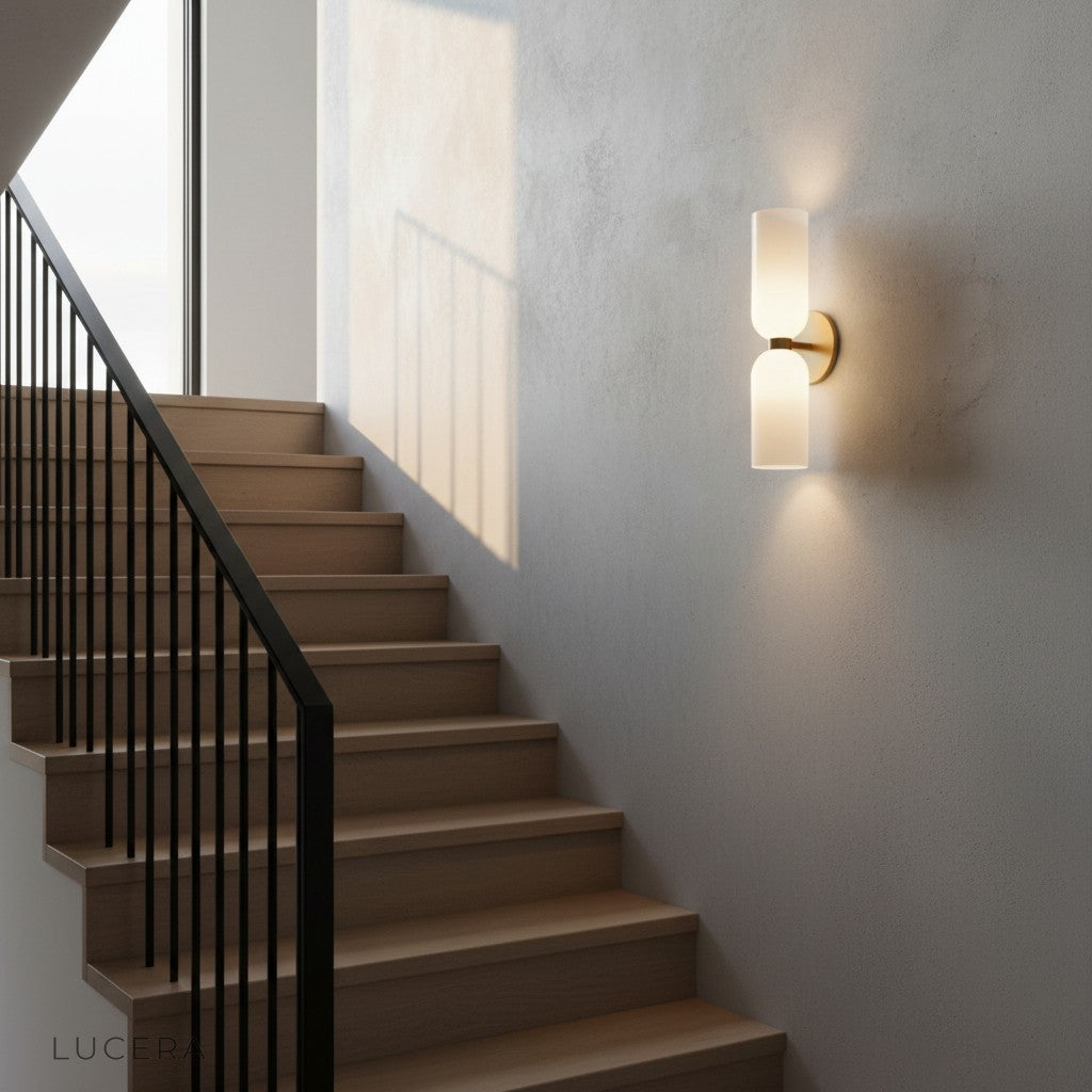 Dolce double sconce in refined dining room corner with brass accents and white glass glow