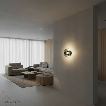 Nighttime mood shot of Domo Disc glass wall sconce above minimalist bed in warm light