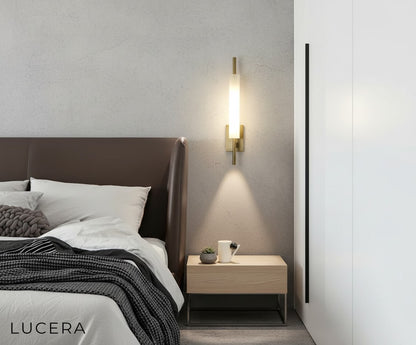 tall glass sconce with gold frame highlighting a staircase wall with subtle shadows and elegance